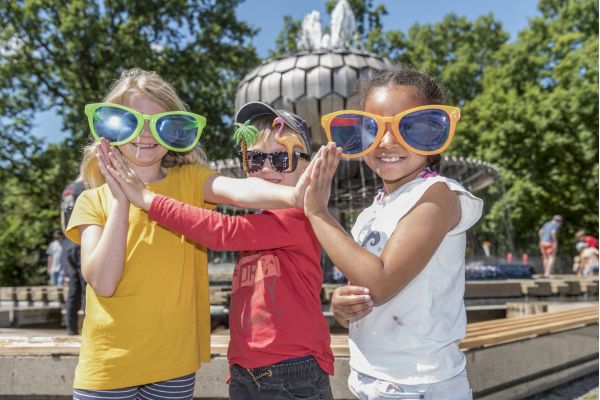 Kinder stehen vor einem Brunnen
