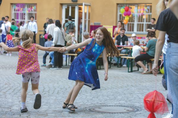 Zwei Kinder tanzen im Hof des Theaters