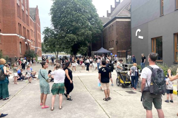Familien versammeln sich im Hof des Theaters