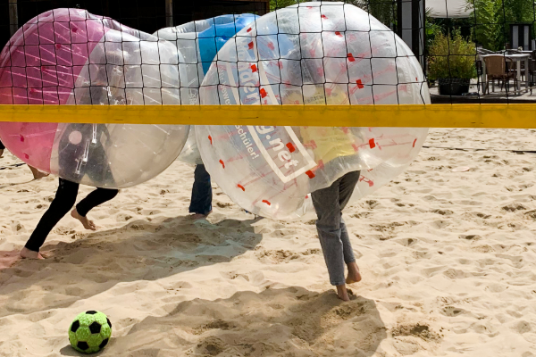 Kinder spielen Bubble-Ball auf dem Sand