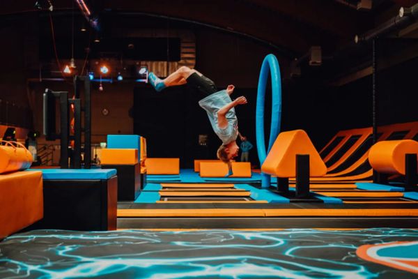 Kind macht Salto in einer Trampolinhalle