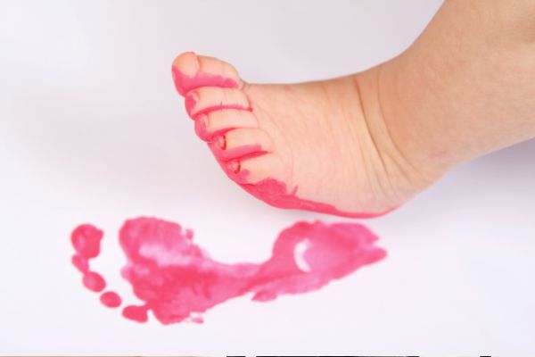Fußabdruck von Baby in rosaner Farbe auf Papier